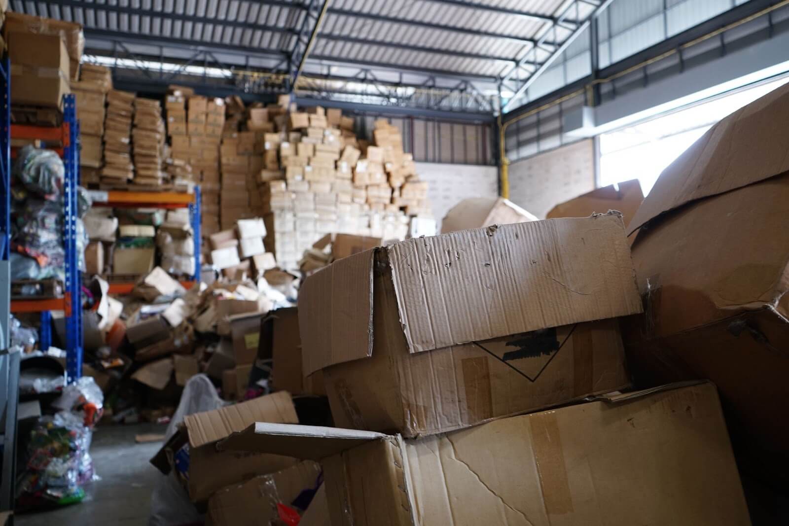 Messy warehouse with cardboard boxes stacked up in piles