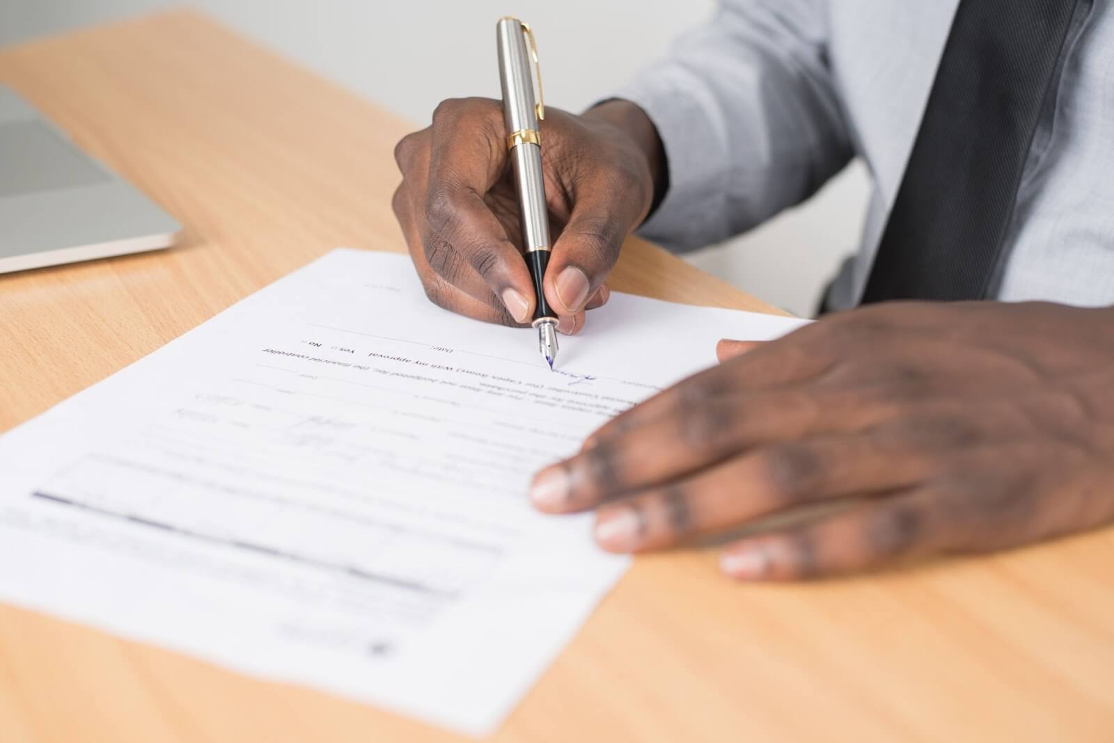 Man filling out application with pen on paper