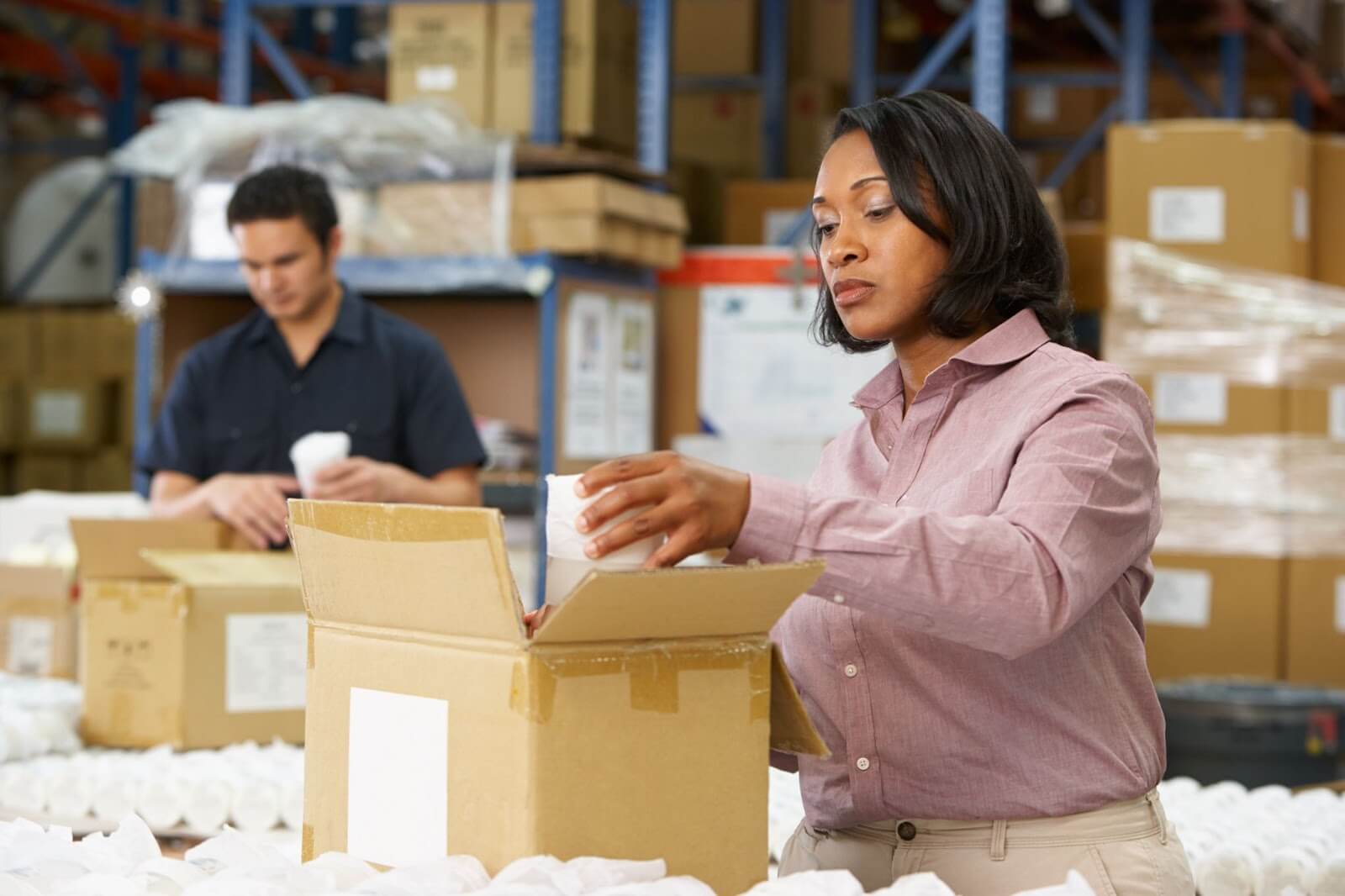Woman packing box in warehouse