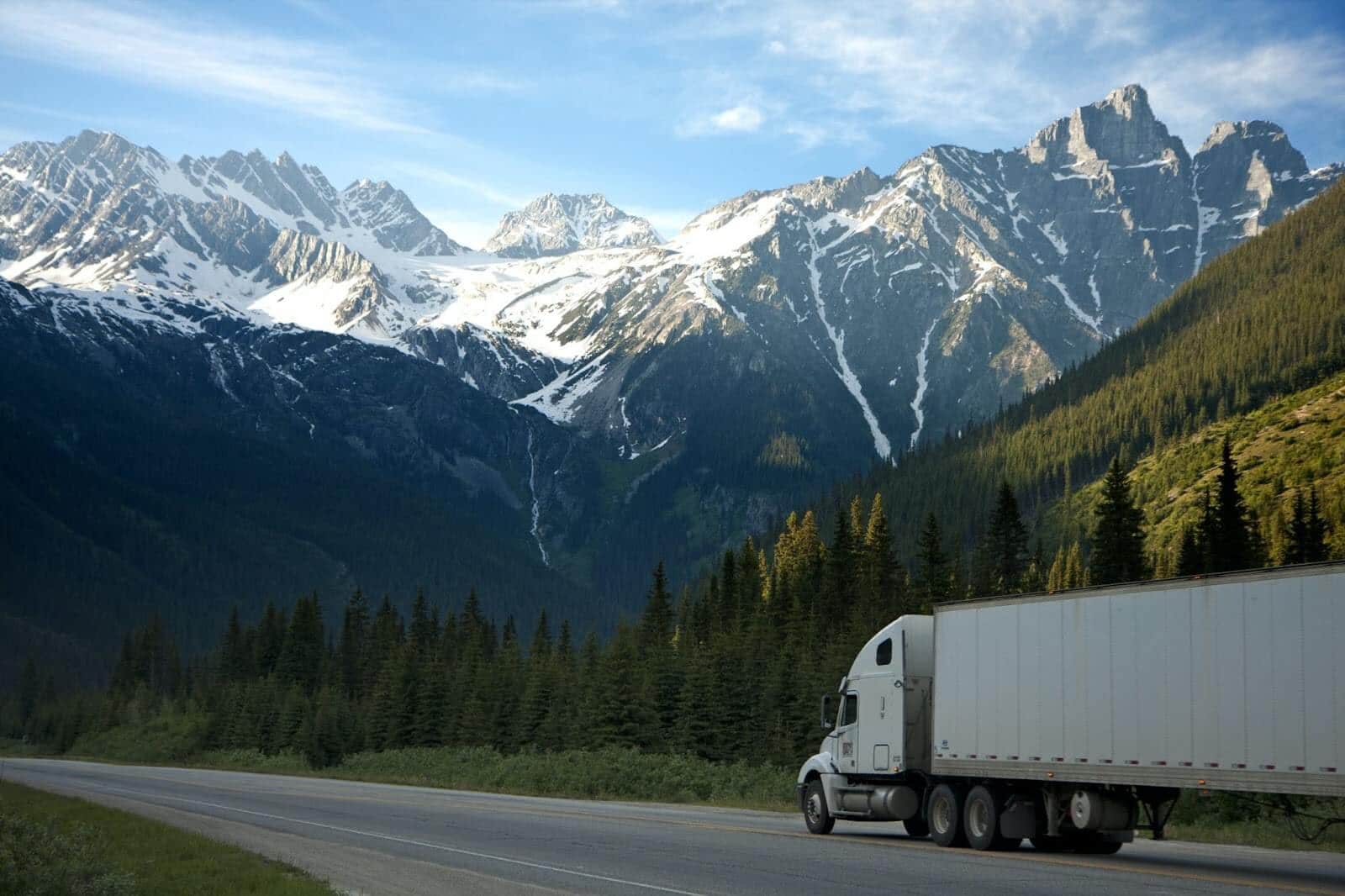 Semi truck driving through mountain landscape